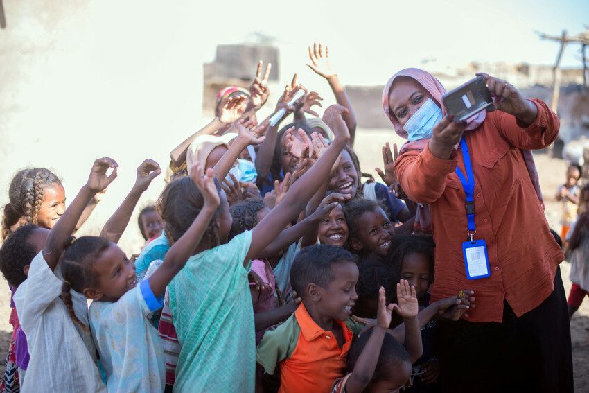 Nahid takes photos of displaced children at a literacy centre in Kassala State. Photo credit: Plan International